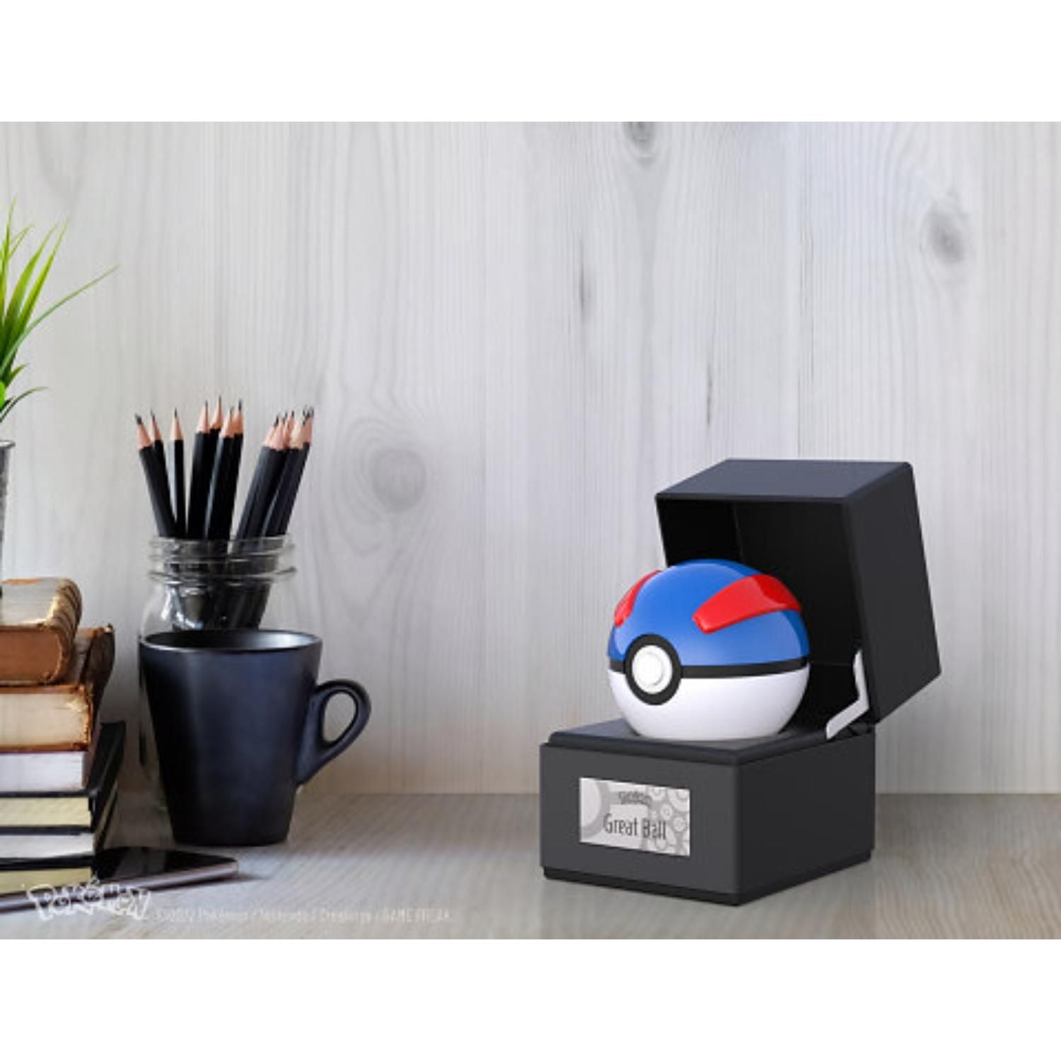 Great Ball die-cast replica in its lit display case on a desk shelf beside books and pencils